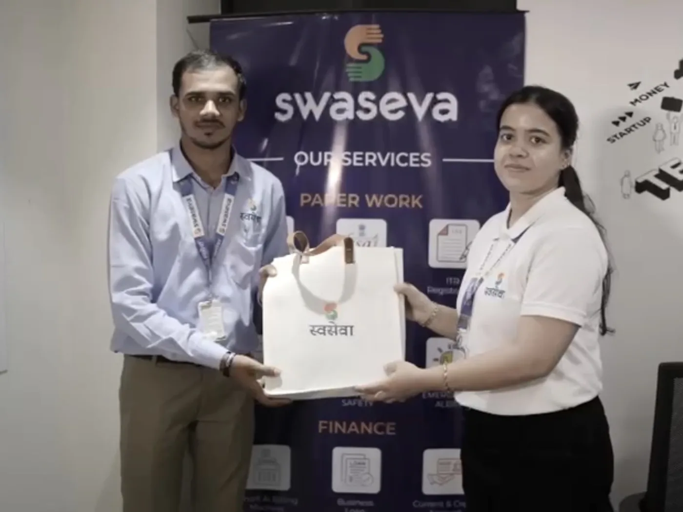 Swaseva team members handing over a document bag at the office counter