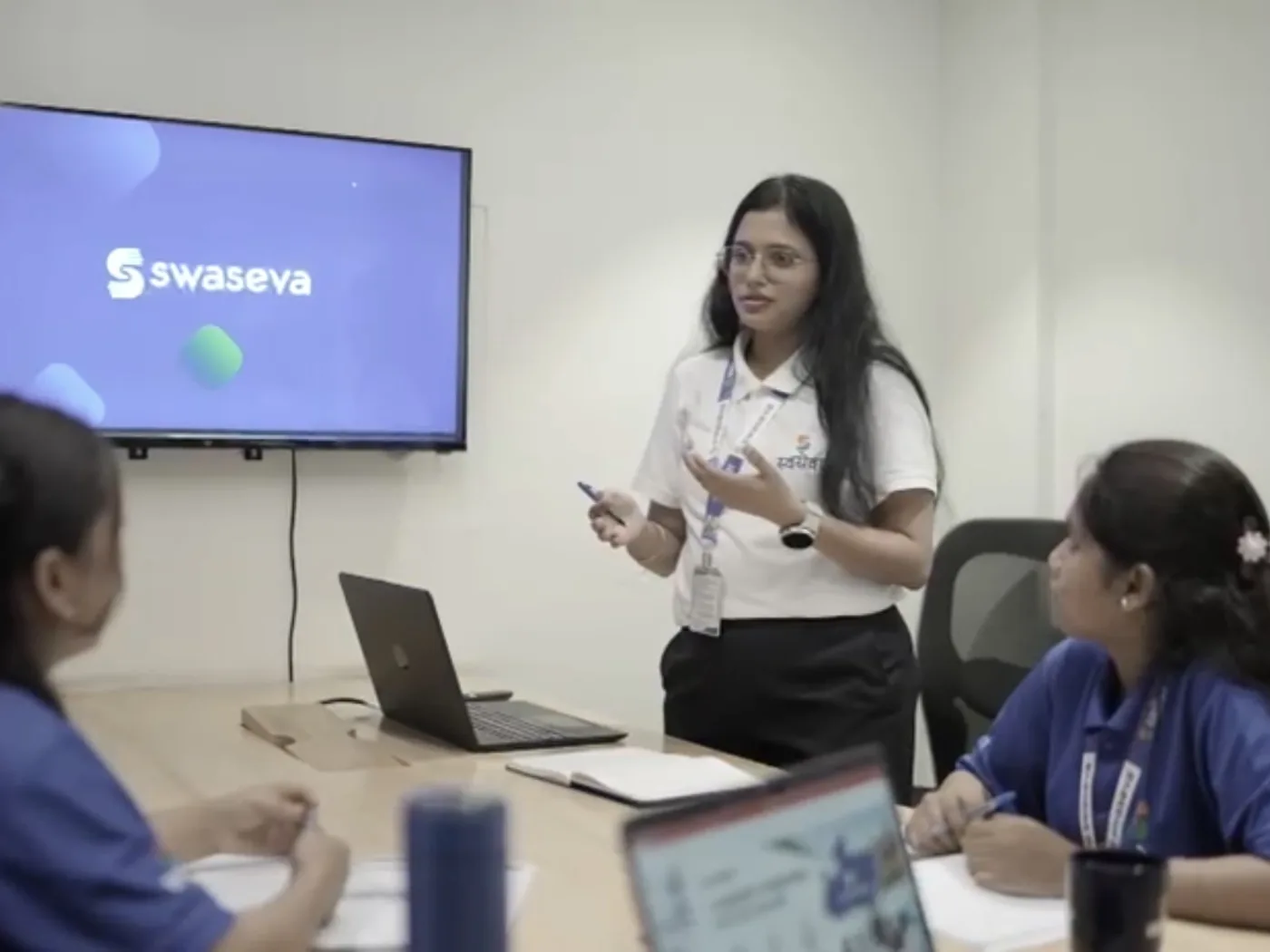 Swaseva team in a meeting room with a presentation on screen